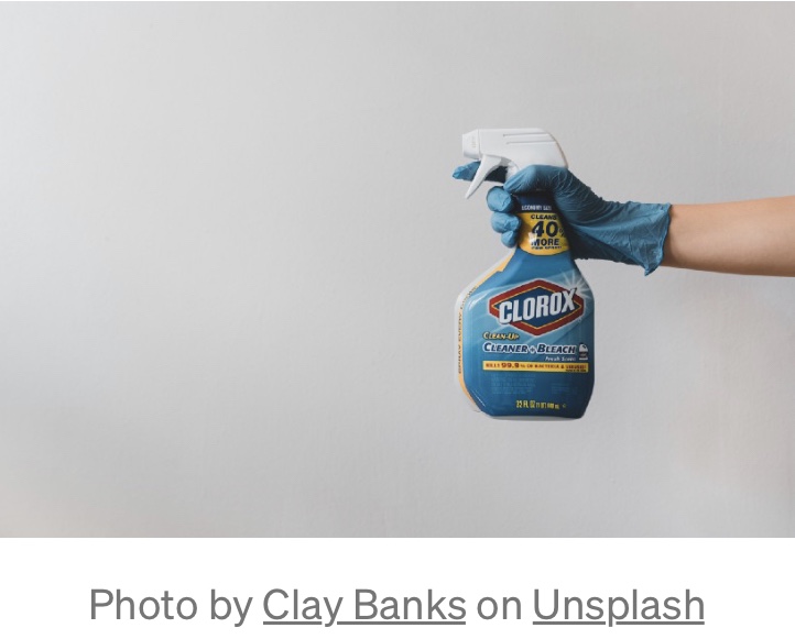A woman points her clorox bleach cleaner at dirt and grime.