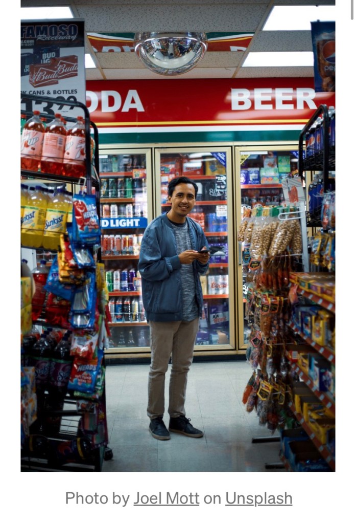 A man smiling at a woman at a gas station.