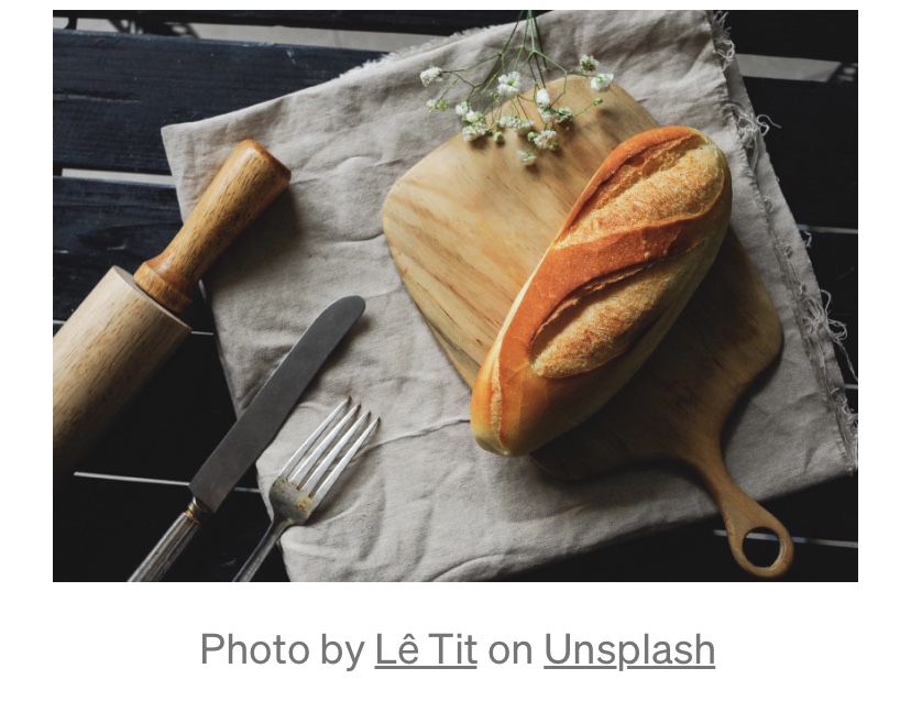 Homemade bread sits on a napkin besides silverware.