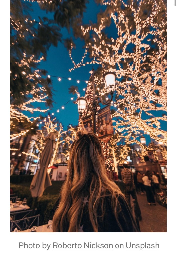 I woman enjoys looking at Christmas lights during the holiday season￼. 
